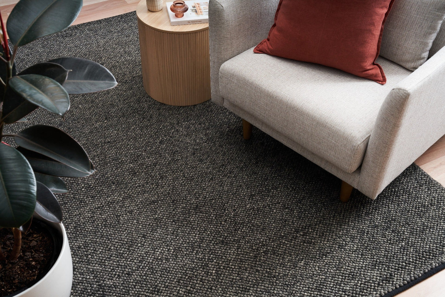 Charcoal textured area rug on hardwood floor