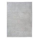 Light grey shag rug with raised circular and wave pattern, close-up