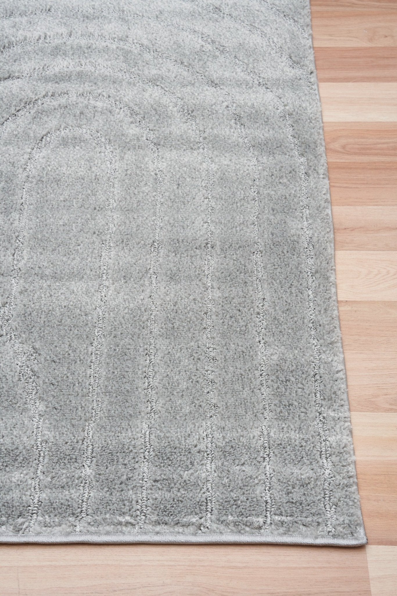 Light grey shag rug with textured surface and subtle speckles, trimmed edge