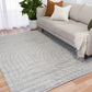 Light grey shag rug with wave and circular stitched motif on hardwood floor