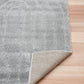 Light grey shag rug showing woven backing and stitched edge on hardwood floor