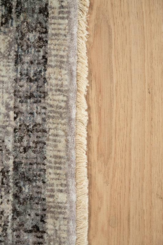 Matana thick-pile rug edge with grey fringe and textured woven border