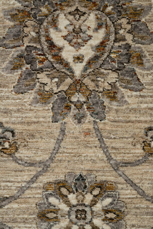 Close-up of multi-tone rug pattern with floral medallion and scroll details on light base