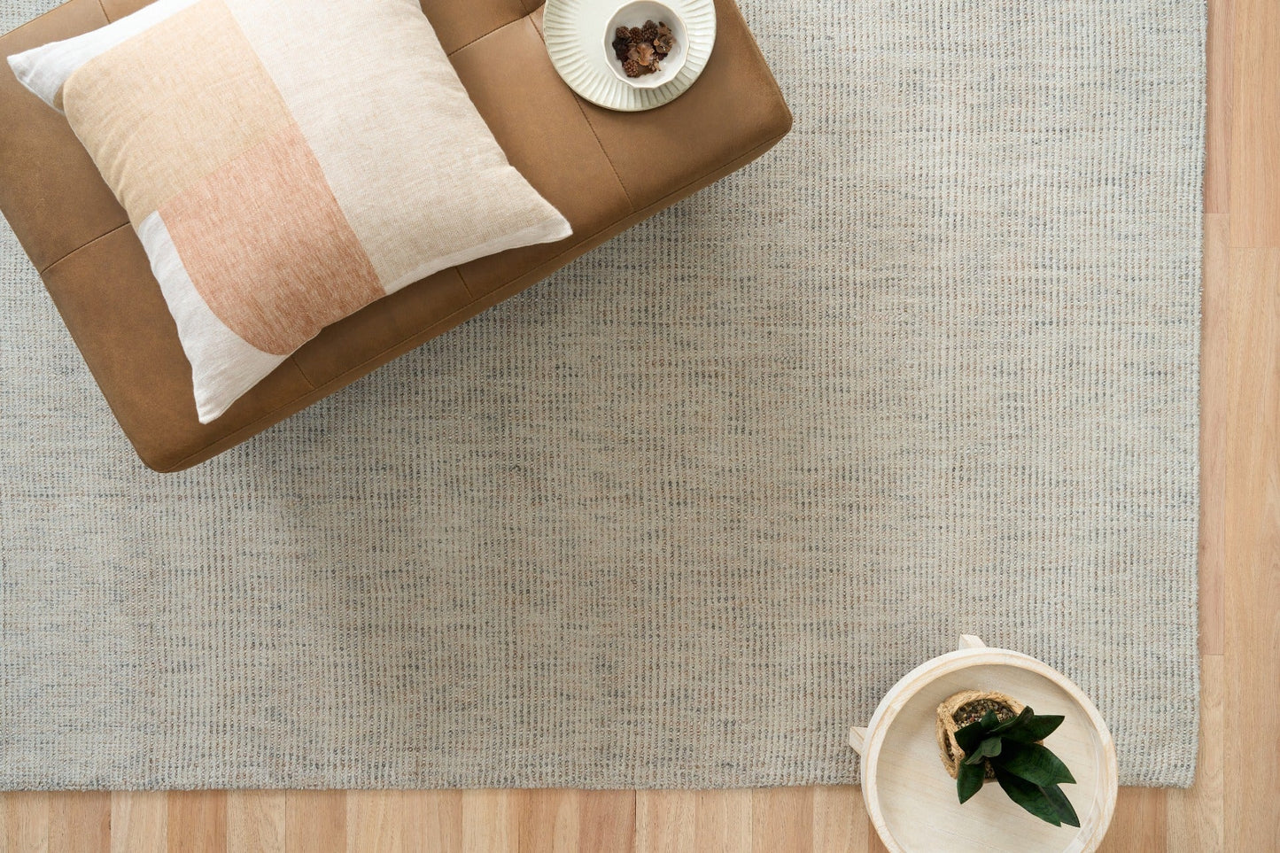 Light gray woven area rug with dense speckled texture and visible border