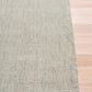 Light gray woven area rug with straight hem and square edge