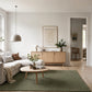 Green area rug in a bright living room with a sectional sofa and coffee table