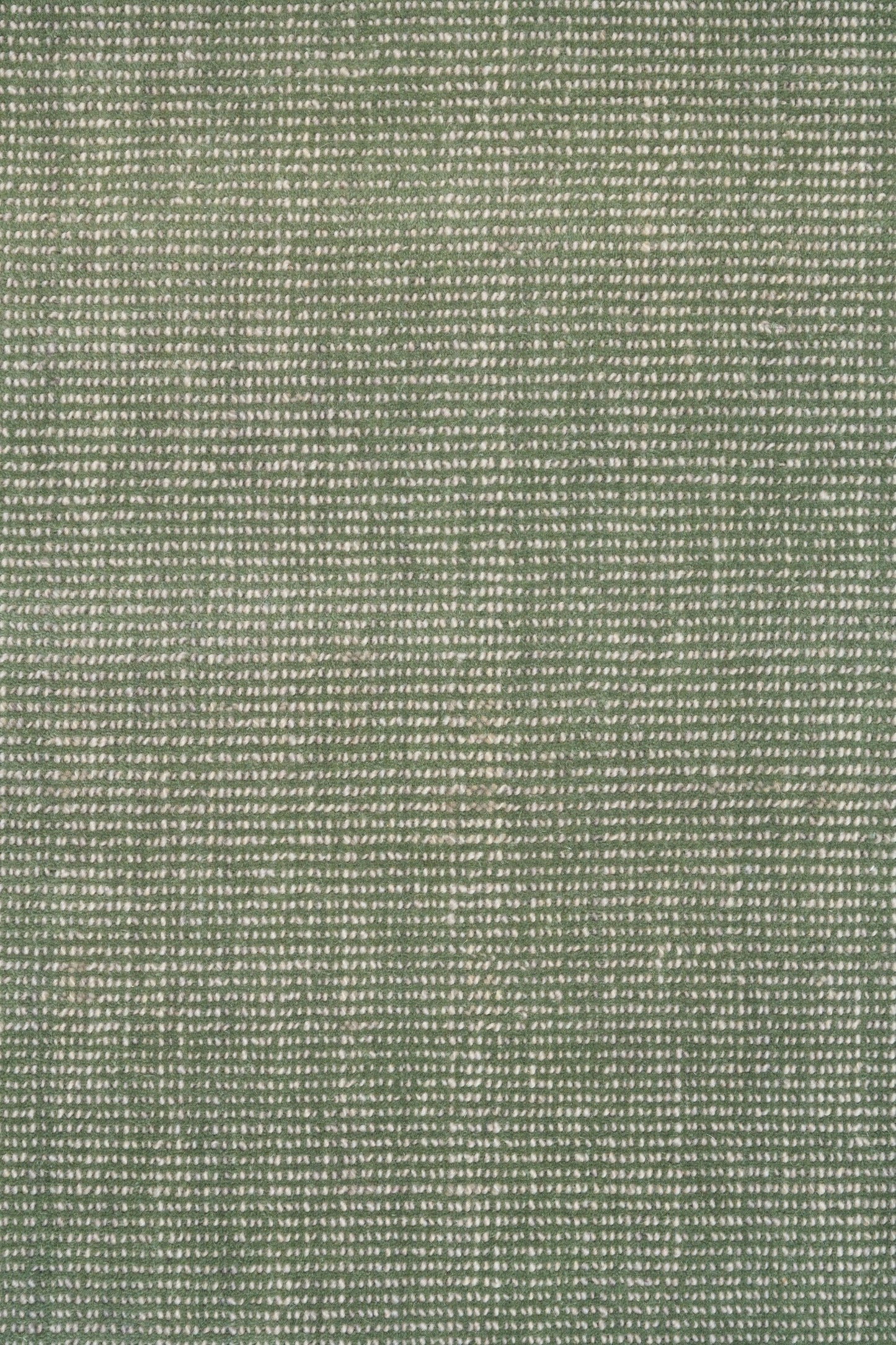 Green textured area rug with tightly woven speckled pattern, close-up view
