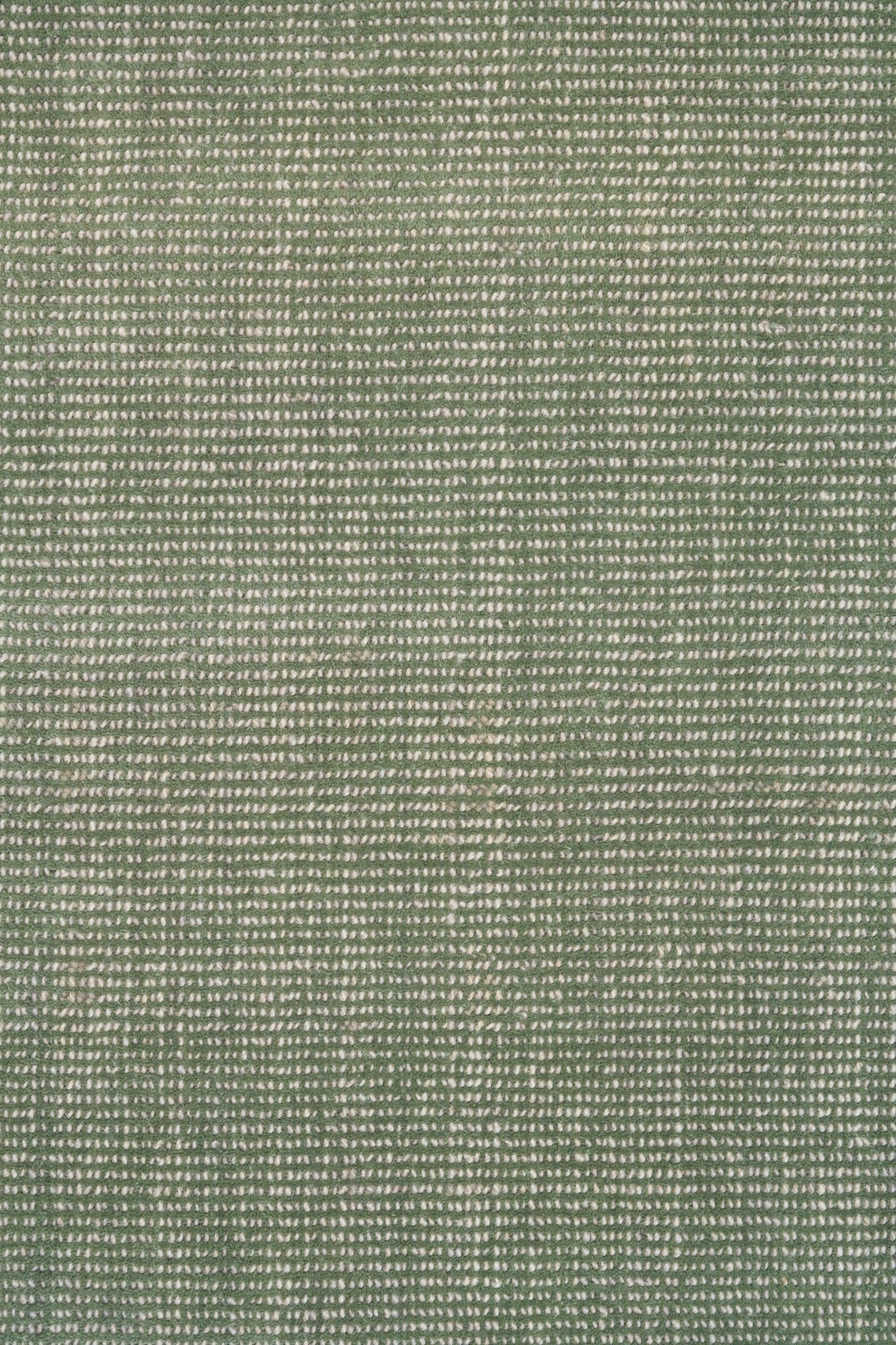 Green textured area rug with tightly woven speckled pattern, close-up view
