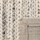 Ivory chunky knit wool rug corner with stitched border detail