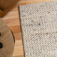 Cream wool rug close-up with dense loop texture and flat, tightly woven surface