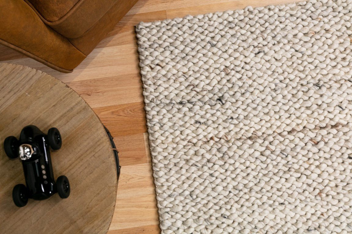 Cream wool rug close-up with dense loop texture and flat, tightly woven surface