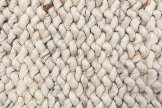 Cream wool rug with chunky loop pile texture and intertwined yarn details