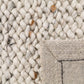 Wool rug corner with thick loop pile and tightly stitched border edge