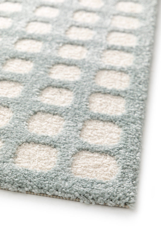 Light blue rug with cream rectangular dot blocks and low-pile border