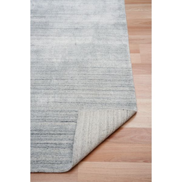 Blue-gray wool floor rug with woven texture and stitched corner border