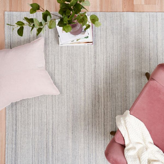 Light grey thick wool rug with subtle linear texture, laid flat with straight edges