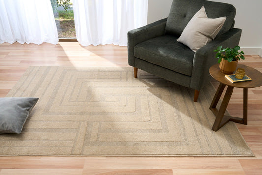 Beige geometric area rug spread on wood floor, square pattern