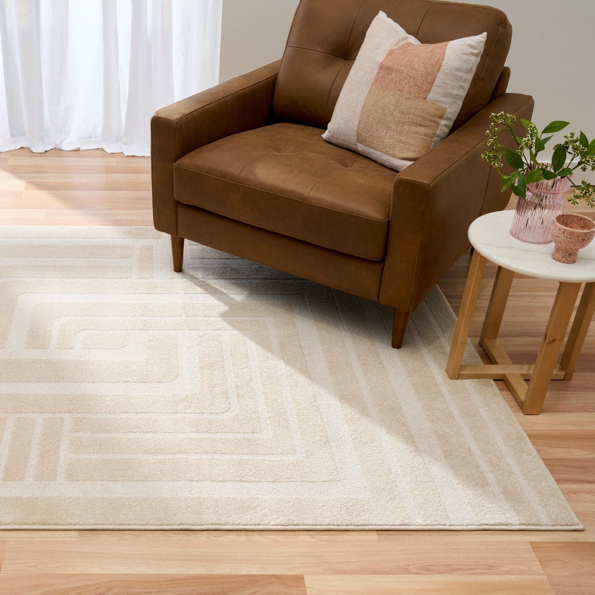 Ozlo ecru patterned area rug under sofa, geometric border