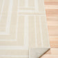 Ozlo ecru patterned area rug corner with stitched edge