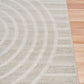 Light gray area rug with abstract arch and stripe motif, side view