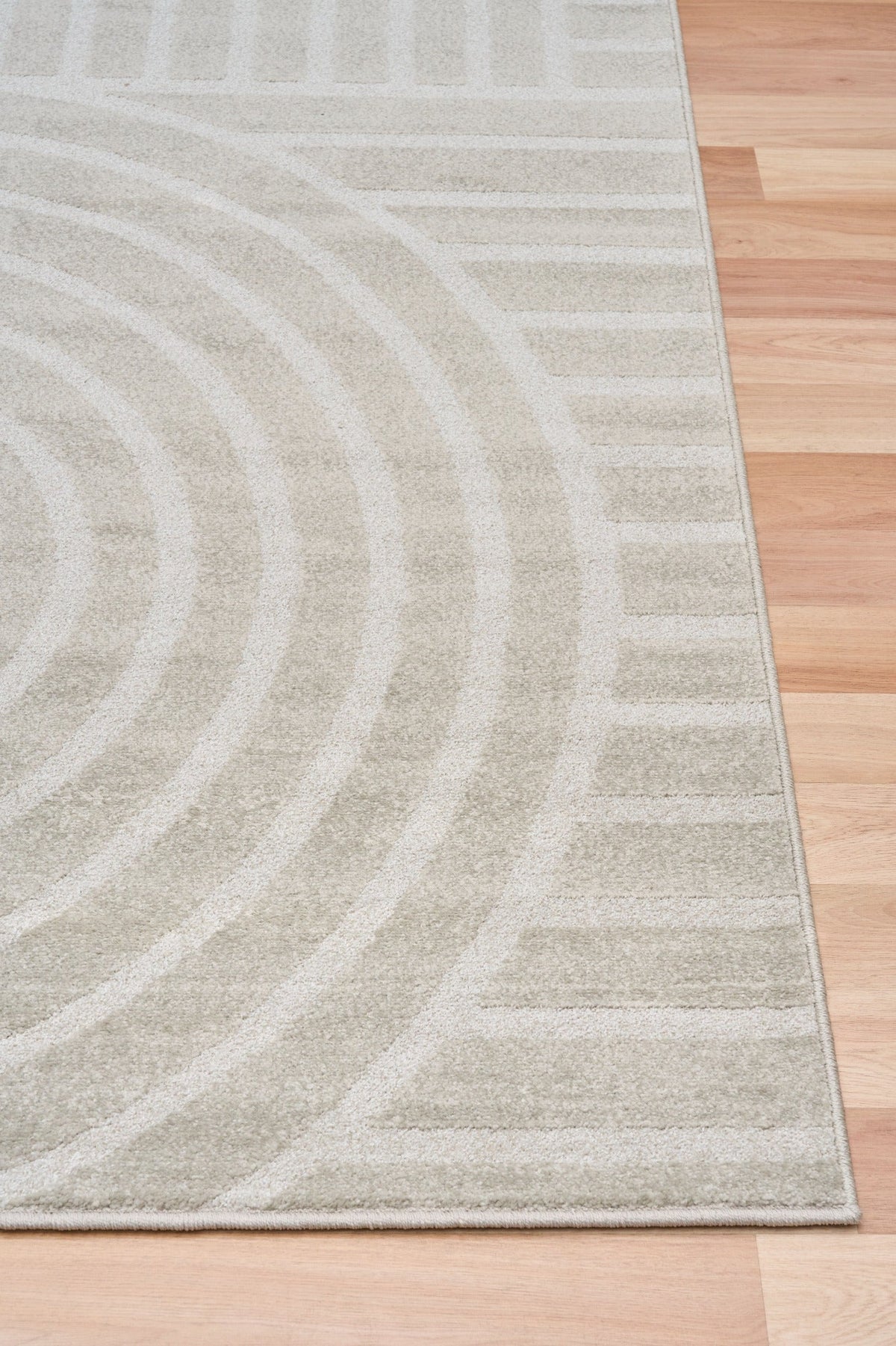 Light gray area rug with abstract arch and stripe motif, side view