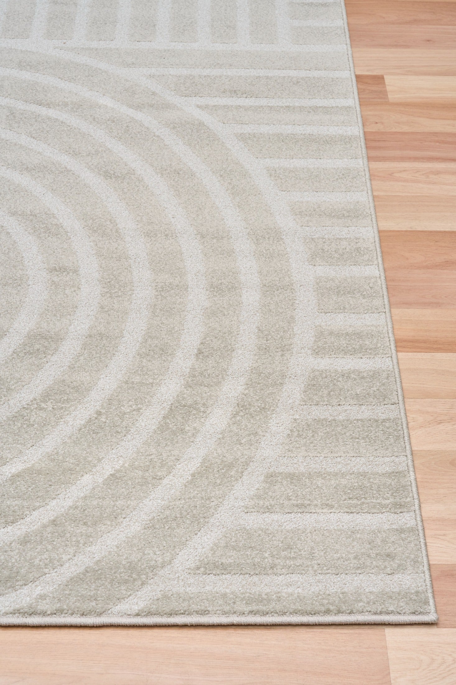 Light gray area rug with abstract arch and stripe motif, side view