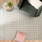 Light gray area rug with abstract arch and bar stripe pattern, corner view with sofa