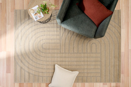 Beige area rug with abstract geometric pattern and curved stripes, edge view
