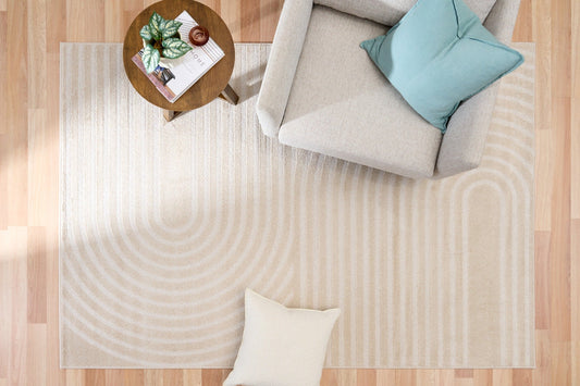 Ecru area rug with concentric swirl stripes, corner view