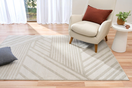 Ash gray geometric area rug with chevron and stripe pattern on wood floor