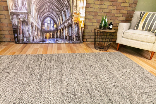 Dark grey wool rug with textured looped pile, laid flat on the floor