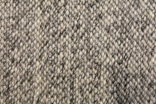 Dark grey wool rug with tight looped texture, close-up pile surface