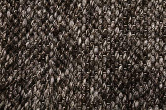 Close-up of dark gray-brown woven wool rug with dense loop texture