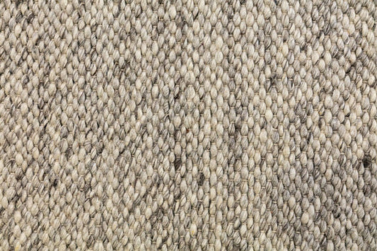Woven smoke wool rug texture close-up in light gray-beige