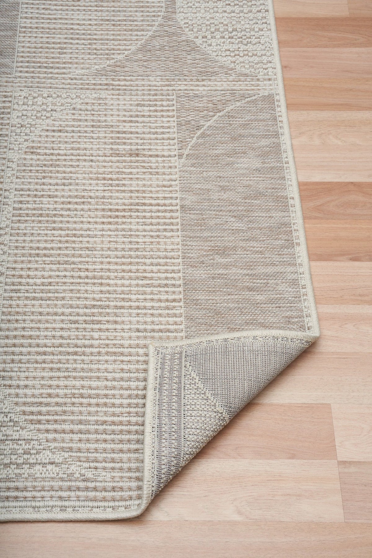 Linen patio rug with border edge and textured weave, light beige and taupe pattern