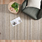Rectangular beige and gray striped woven area rug with textured surface.