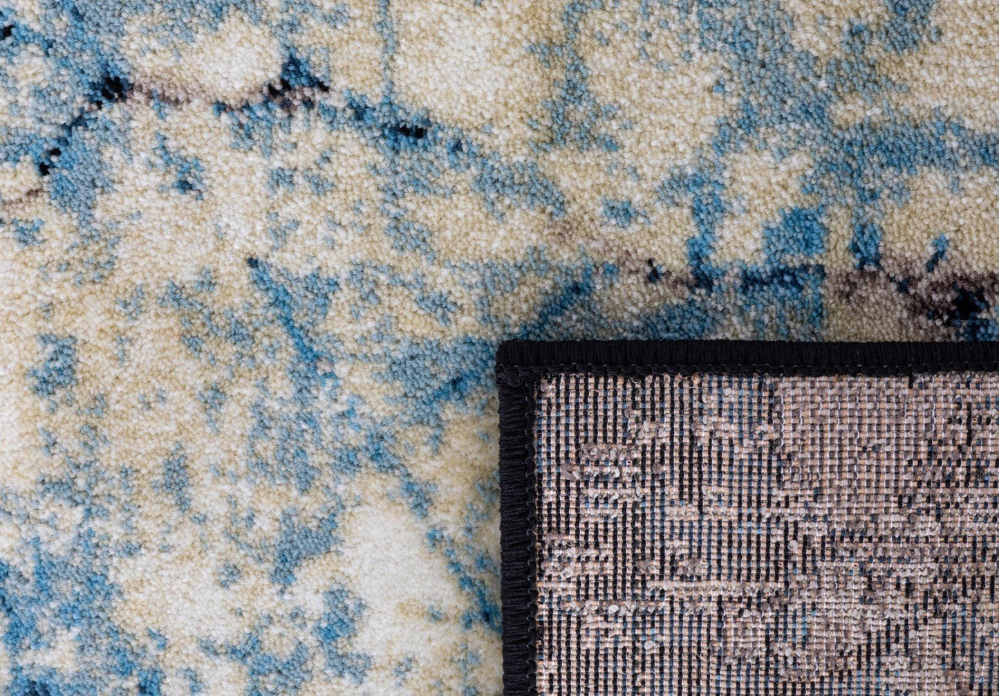 Rug corner detail with black bound edge and blue/cream distressed surface | Raffia Mat 1440 Sky Modern Abstract Living Room Rug - Rugs Point Australia