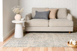 Abstract blue-gray and beige area rug with flat, distressed texture