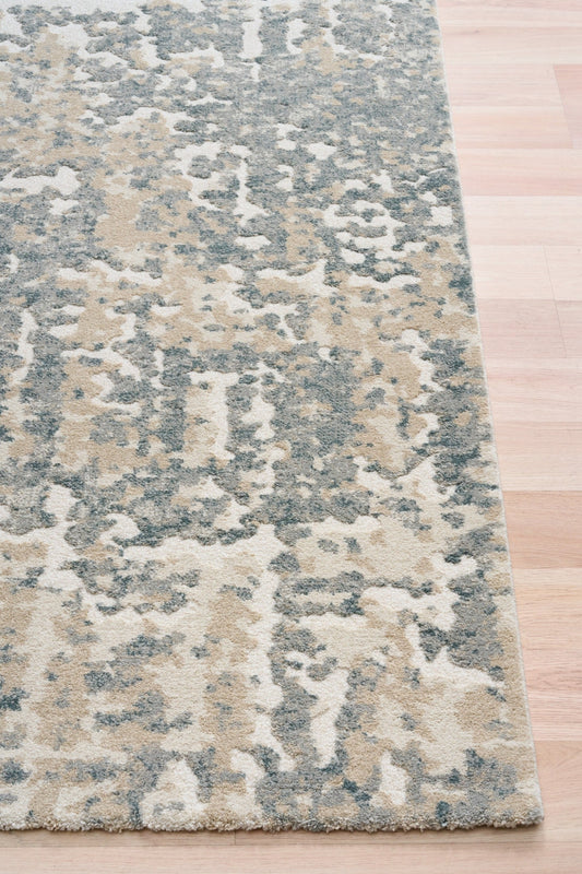Rectangular abstract blue-gray and beige area rug with mottled texture
