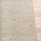 Savoy beige area rug corner with looped texture and low pile, side view