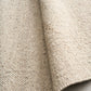 Savoy beige area rug edge detail with woven border and backing