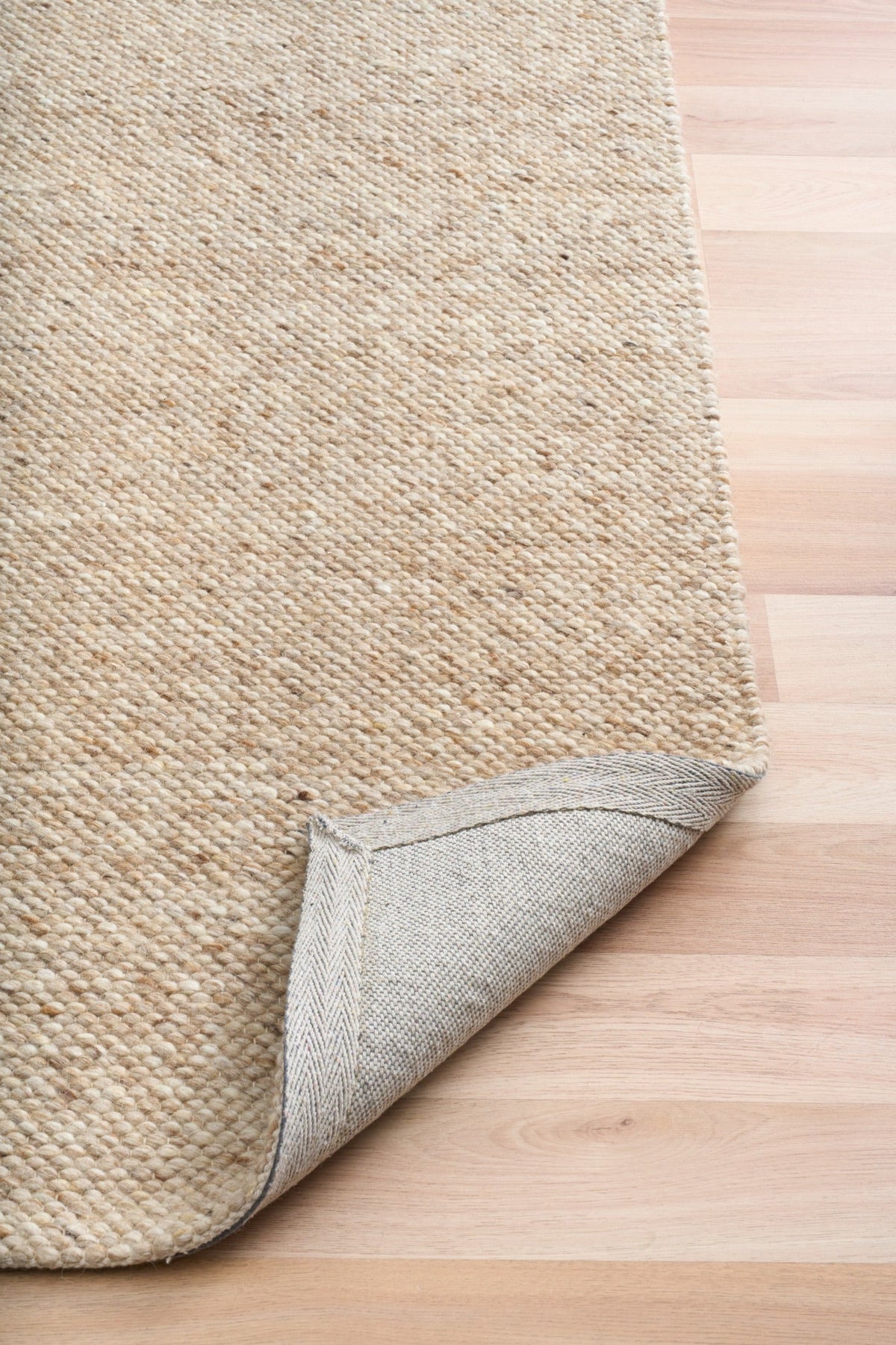 SAVOY BROWN beige rug corner with stitched edge and light backing