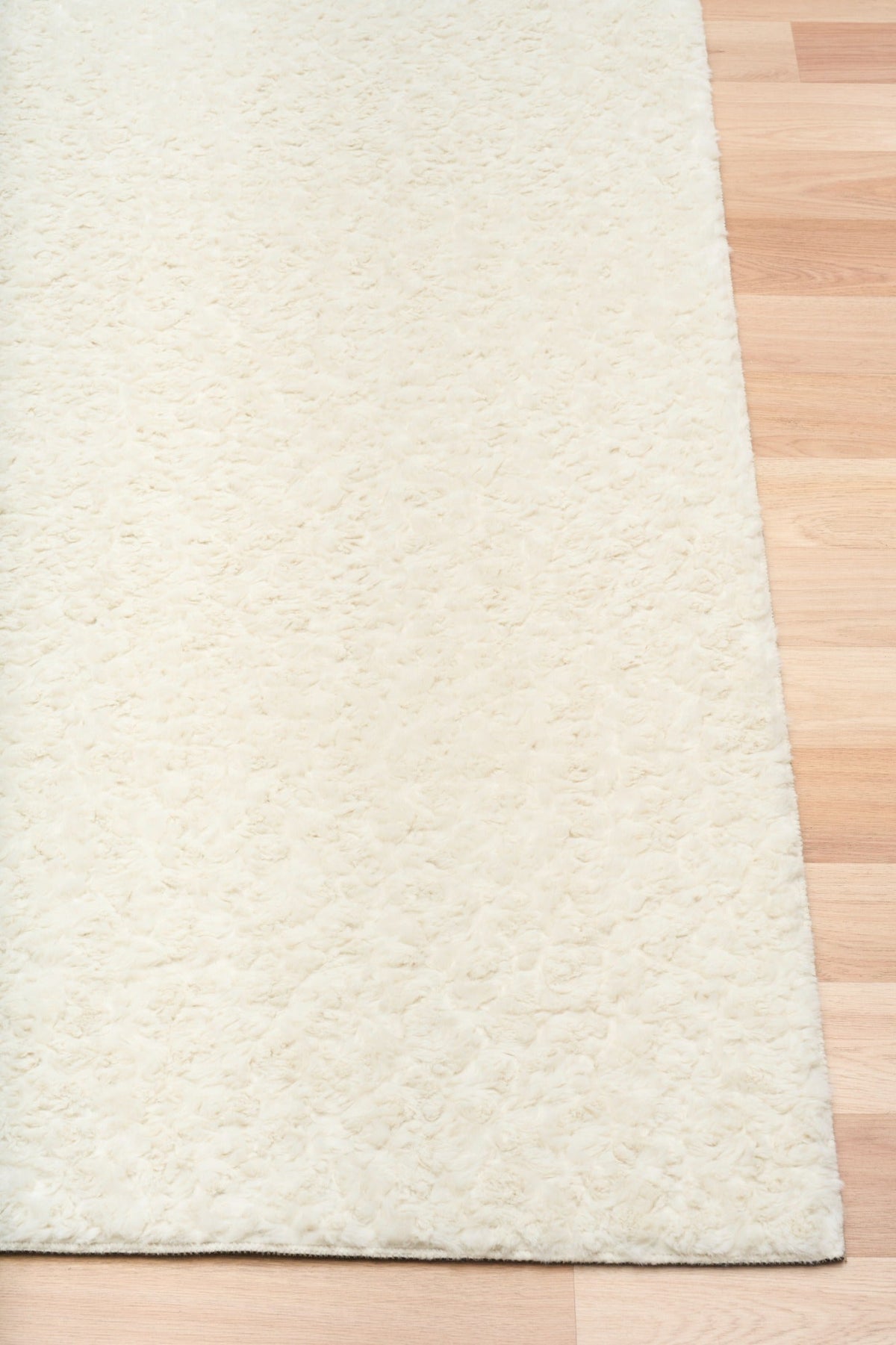 Cream sherpa rug with textured edge and dark underside backing