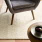 Cream sherpa rug with thick curly pile, visible corner