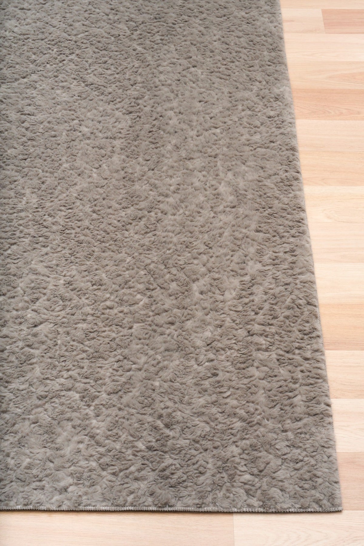 Gray shaggy rug with dense plush fibers and bound edge