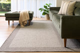 Taupe area rug with low-pile flat weave, rectangular shape on wooden floor