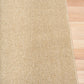 Beige textured area rug with straight stitched border and flat weave