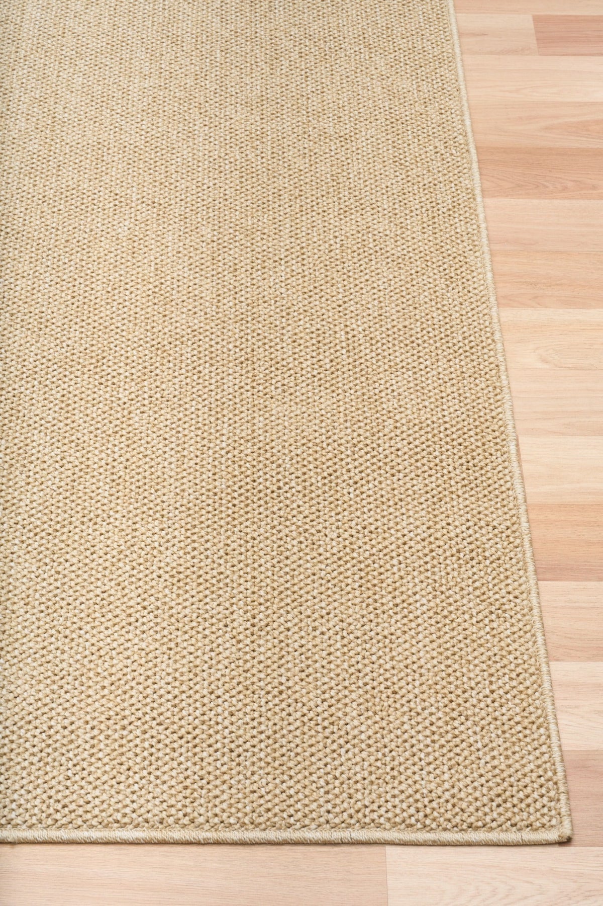 Beige textured area rug with straight stitched border and flat weave