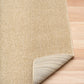 Beige textured area rug corner with bound edge and looped weave