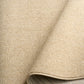 Beige area rug edge with rounded bound trim and close-up weave